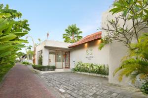 a house with a cobblestone street in front of it at Manca Villa Canggu by Ini Vie Hospitality in Canggu