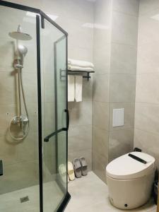 een badkamer met een toilet en een glazen douche bij Zebulun Hotel in Lijiang