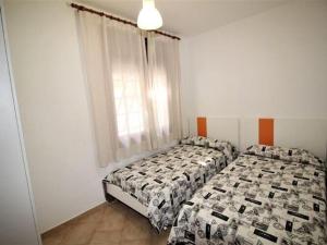 a bedroom with two beds and a window at Apartments La Pineda, Playa de Pals in Begur