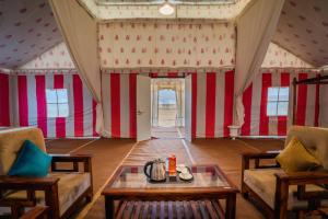 a room with red and white striped walls and a table at Sam Sand Dunes Jaisalmer in Jaisalmer