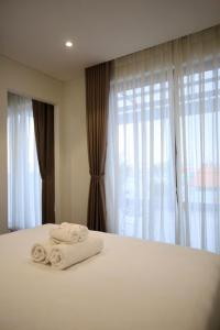 a bedroom with white towels on a bed with a window at Cityhouse Villea in Ho Chi Minh City