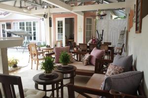 an outdoor patio with tables and chairs and tablesktop at The Sangtus Home in Babakan Madang