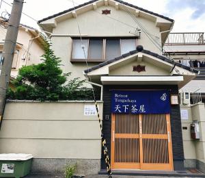 a building with a blue sign in front of it at Retreat Tengachaya 旅趣 天下茶屋 in Osaka
