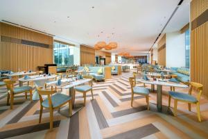 三亜市にあるSanya Haitang Bay Moutai Resort Classic Hotelのテーブルと椅子が備わるレストラン