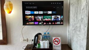 a computer monitor hanging on a wall above a desk at PP Insula in Phi Phi Islands