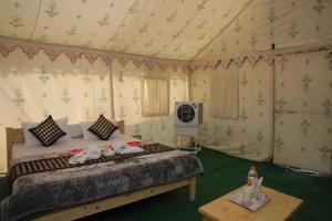 ein Schlafzimmer mit einem Bett in einem Zelt in der Unterkunft Charisma Desert Camping in Jaisalmer