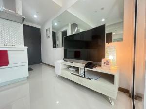 a living room with a large flat screen tv at Sakura House in Manila