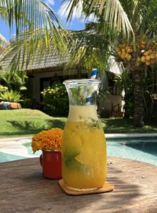 a drink in a glass vase sitting on a table at Mule Malu Tropical Stay in Uluwatu