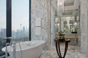 ein Bad mit einer Badewanne und einem großen Fenster in der Unterkunft The St. Regis Kuala Lumpur in Kuala Lumpur