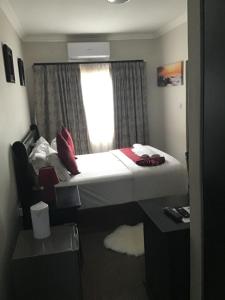 a hotel room with a bed and a window at Antique Home BnB in Gaborone