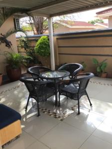 a patio with three chairs and a table on a patio at Antique Home BnB in Gaborone