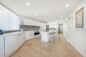 a kitchen with white cabinets and a large window at m1 Resort in Maroochydore