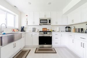 a white kitchen with a stove and a sink at Seasons at Leschi Hillsides in Seattle