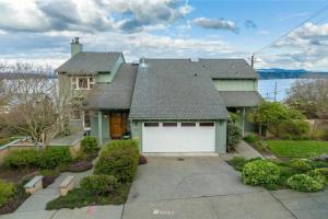 een groen huis met een witte garagedeur bij Seasons at Leschi Hillsides in Seattle