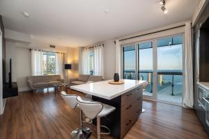 een woonkamer met een tafel en stoelen en een groot raam bij Designer condo w/ CN Tower view & parking in Toronto