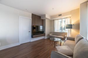 a living room with a couch and a tv at Designer condo w/ CN Tower view & parking in Toronto