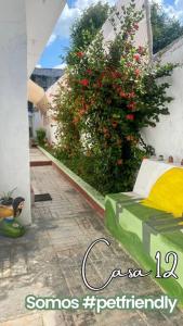 una habitación con una cama y un arbusto con flores rojas en Casa 12 en Campeche