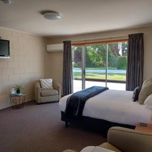 a bedroom with a large bed and a large window at Flaxbourne Motels in Ward