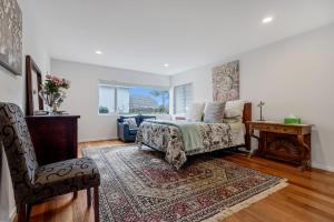 a bedroom with a bed and a table and a chair at The Bays Bed & Breakfast in Auckland