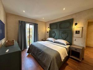 a bedroom with a large bed with a green headboard at Villa Serena Val’Quirico in Santeagueda
