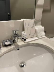 a bathroom sink with books on a mirror at Stacia Hotel powered by Cocotel in Cebu City