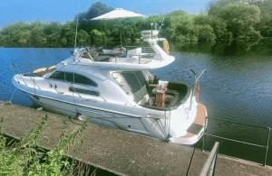 a white boat is parked on the water at Spring Gardens Retreat And Spa Private hottub,Sauna,Massage in Great Malvern