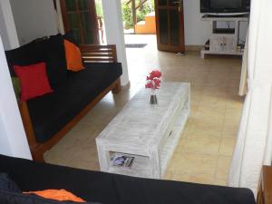 a living room with a couch and a table with flowers on it at Villa Tenganan, Candidasa, Bali in Candidasa