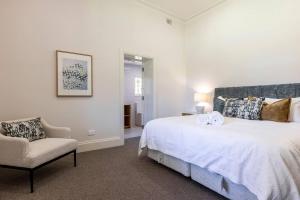 a bedroom with a large bed and a chair at The Residence at Schubert Estate in Nuriootpa