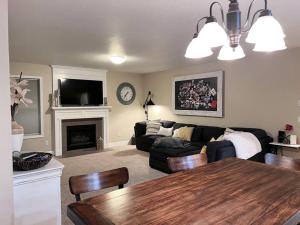 een woonkamer met een zwarte bank en een open haard bij Sopra Bella- 4 bedroom home in Corvallis