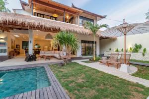 a villa with a swimming pool and a house at Villa Jodoh - Exciting Chic 4BR Stylish Villa Near Seminyak, Perfect for a Trendy Getaway in Kerobokan