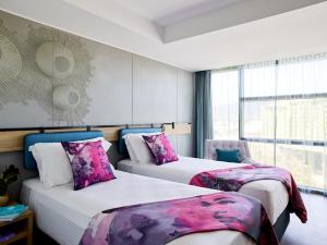 a hotel room with two beds and a window at Crystalbrook Flynn in Cairns