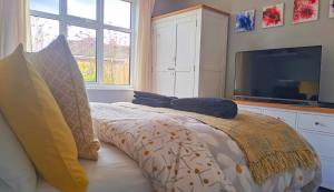 a bedroom with a bed with pillows and a flat screen tv at Greenfields Spa with private hottub New listing in Malvern Link