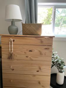 a wooden dresser with a lamp on top of it at Private studio near Green Lake/Lightrail/I-5 in Seattle