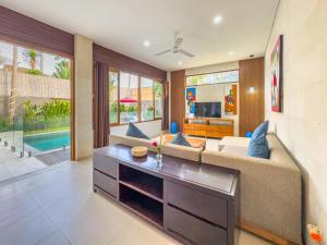 een woonkamer met een bank en een tafel bij Villa Echo Taman Bali in Canggu