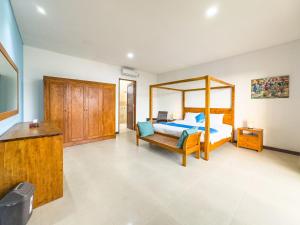 a bedroom with a bed and a wooden canopy bed at Villa Echo Taman Bali in Canggu