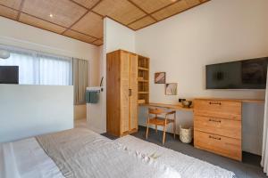 a bedroom with a bed and a desk and a television at Villa Jodoh - Exciting Chic 4BR Stylish Villa Near Seminyak, Perfect for a Trendy Getaway in Kerobokan
