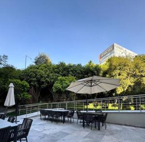 un patio con mesas, sillas y una sombrilla en The best place to live and work, en Ciudad de México