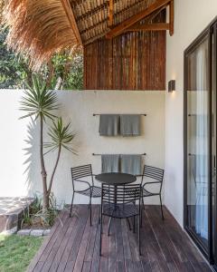 a patio with a table and chairs on a deck at Villa Jodoh - Exciting Chic 4BR Stylish Villa Near Seminyak, Perfect for a Trendy Getaway in Kerobokan
