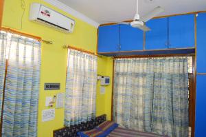 een kamer met blauwe en gele muren en gordijnen bij LAVISH Fully Furnished HOMESTAY - ISH, Atithya with various free amenities in Lucknow, INDIA in Lucknow