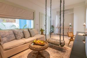 a living room with a couch and a bowl of fruit on a table at Malahini Kuda Bandos Resort in North Male Atoll