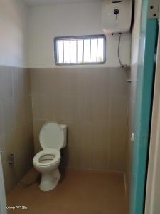 a small bathroom with a toilet and a window at BHELENA GUEST HOUSE in Kelimutu