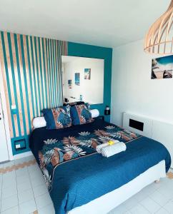 une chambre avec un grand lit avec une couverture bleue dans l'établissement Magnifique logement vue mer!, à Saint-François
