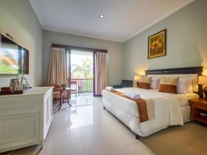 a large bedroom with a large bed and a balcony at U Tube Hotel in Uluwatu