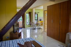a room with a bed and a kitchen with a table at Thai Life Guesthouse Khaolak in Khao Lak