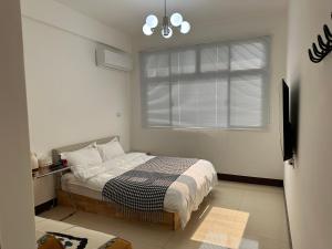 a small bedroom with a bed and a window at 金門且停民宿 可包棟 好停車 近市區 in Jinning