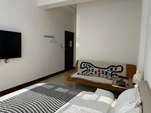a bedroom with a bed and a couch and a tv at 金門且停民宿 可包棟 好停車 近市區 in Jinning