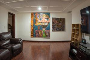 ein Wohnzimmer mit einem Sofa und einem Gemälde an der Wand in der Unterkunft Penthouse Los Colomos in Guadalajara