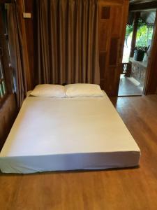 a large white bed in a room at Oh taley resort in Rayong
