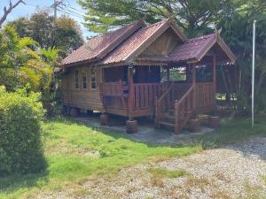 a large wooden cabin with a porch in a yard at Oh taley resort in Rayong