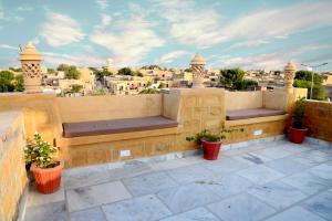 a balcony with two benches and a view of a city at The Travel Bug Jaisalmer in Jaisalmer